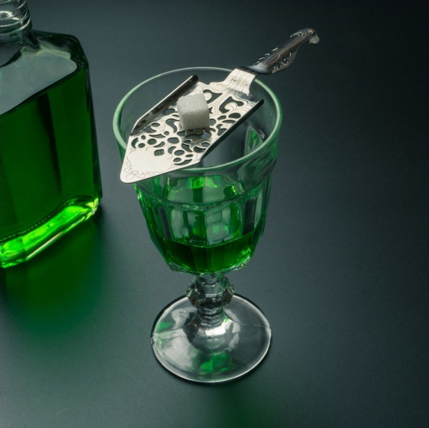 Glas med absint och en sockerbit redo att hällas vatten över